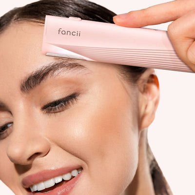 Leah Lighted Dermaplaner Facial Hair Removal + Exfoliating Tool from Fancii & Co. removing hair from eyebrow in Pink