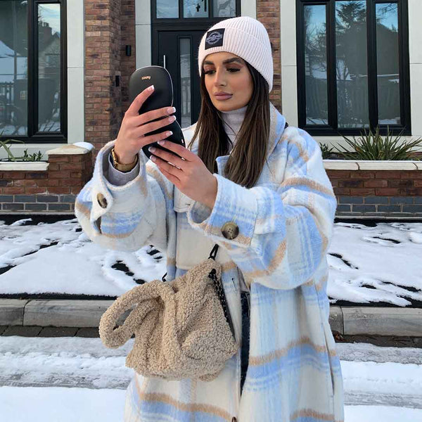 Woman using Black Mila lighted compact to check her makeup outside Black